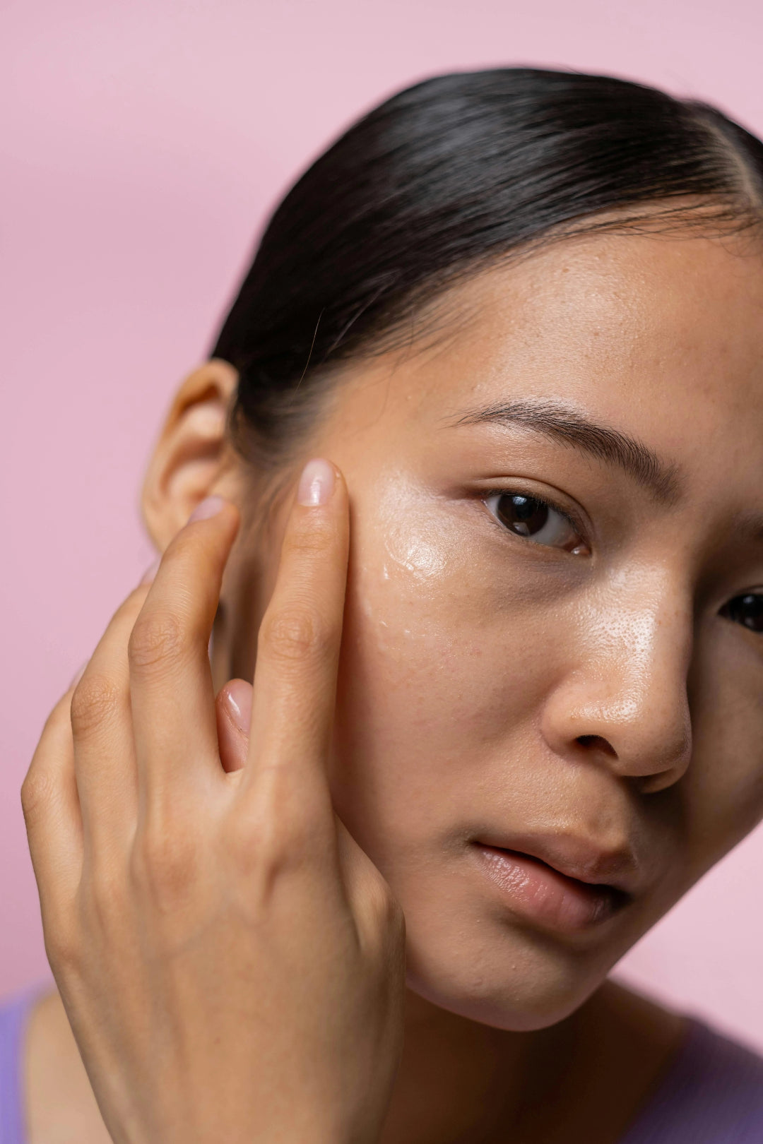 woman applying moisturizer on her clear skin
