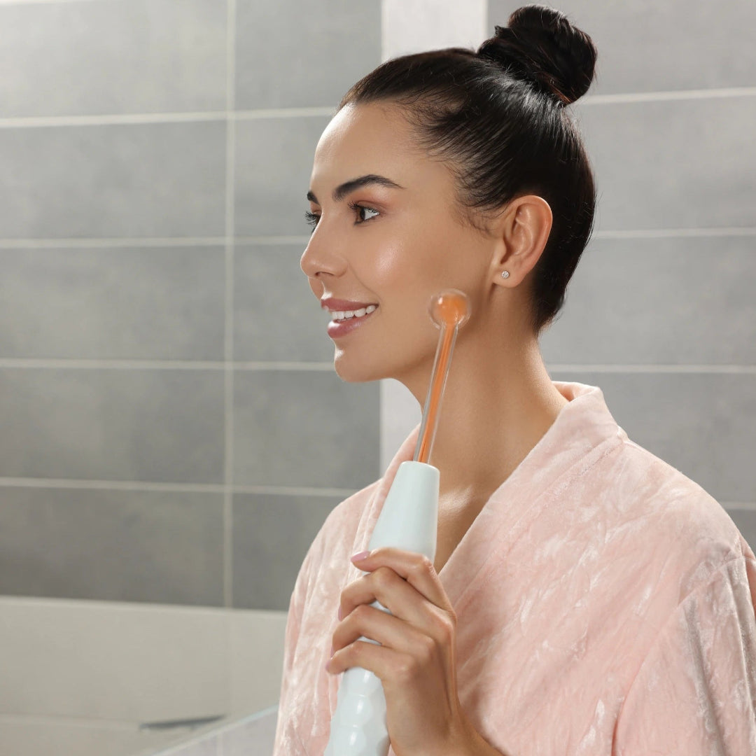 Woman using high frequency mask in her bathroom